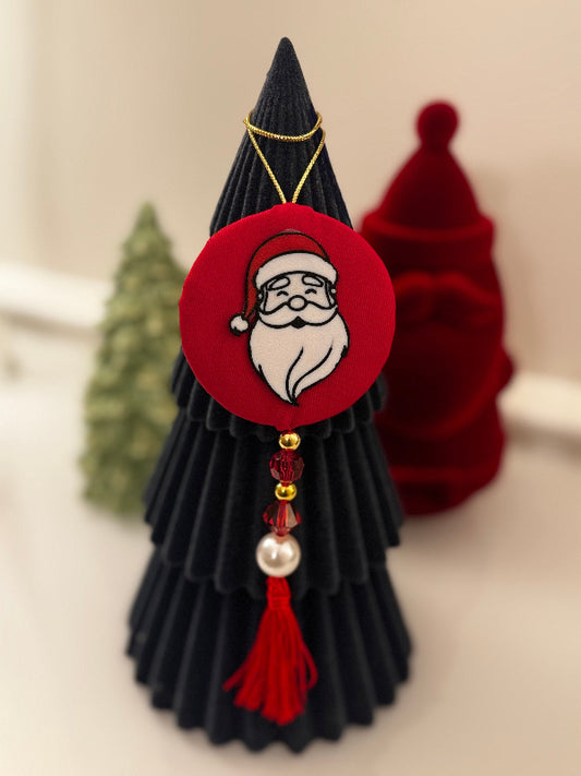 Decorative Christmas tree ornament with Santa Claus face on a neutral background