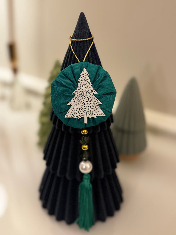 Decorative Christmas tree ornament with black, green, and gold colors on a neutral background.