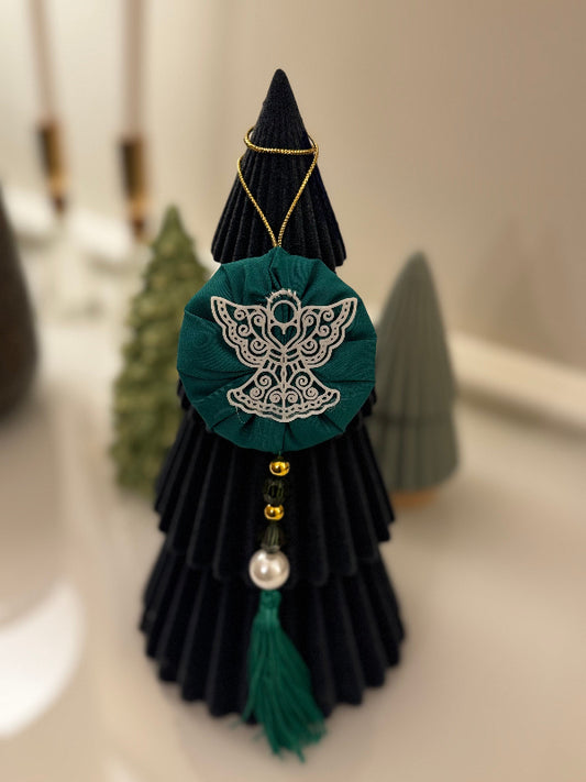 Decorative black and green tree with angel design on a neutral background